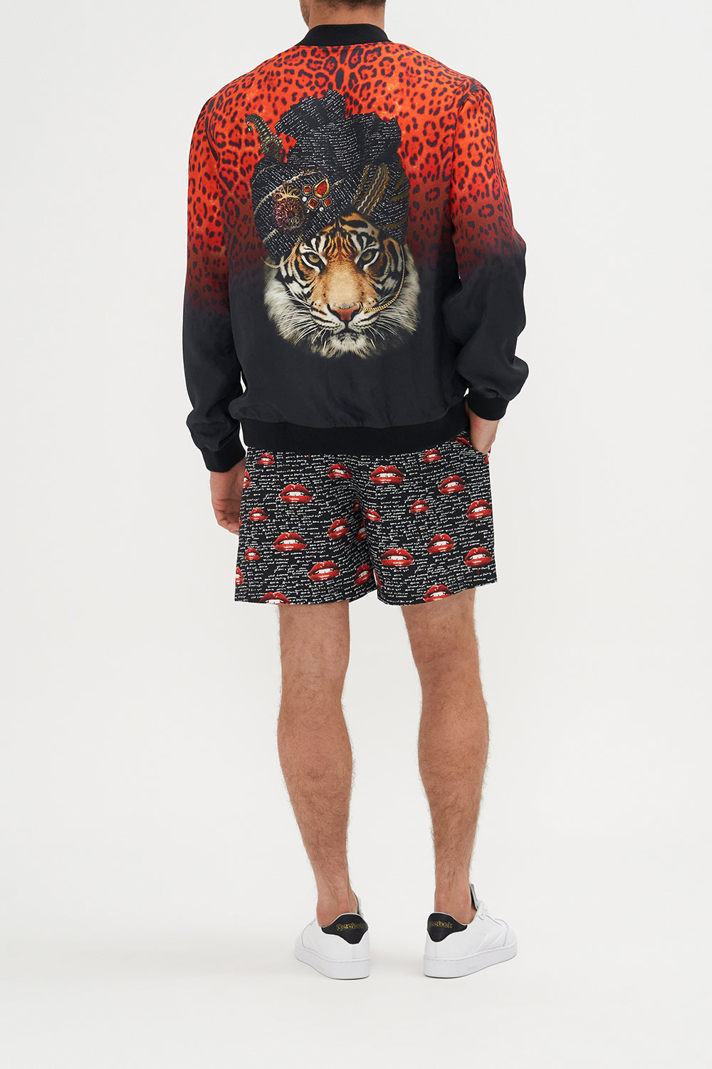 Back view of model wearing Hotel Franks by CAMILLA mens reversible bomber jacket in black and red Chaos Magic print