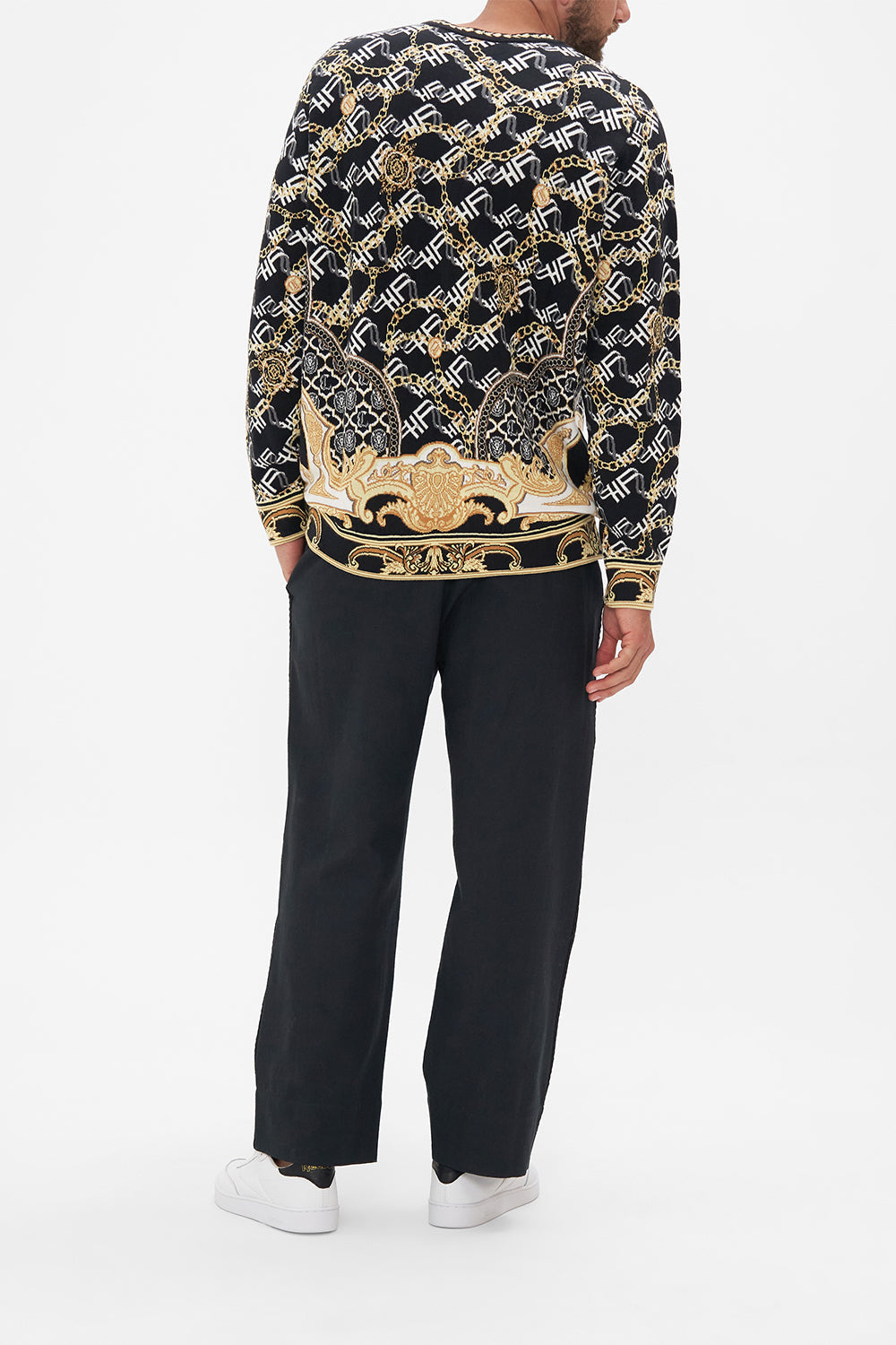 Back view of model wearing Hotel Franks by CAMILLA mens oversized knit sweater in black and gold Tether Me Not print