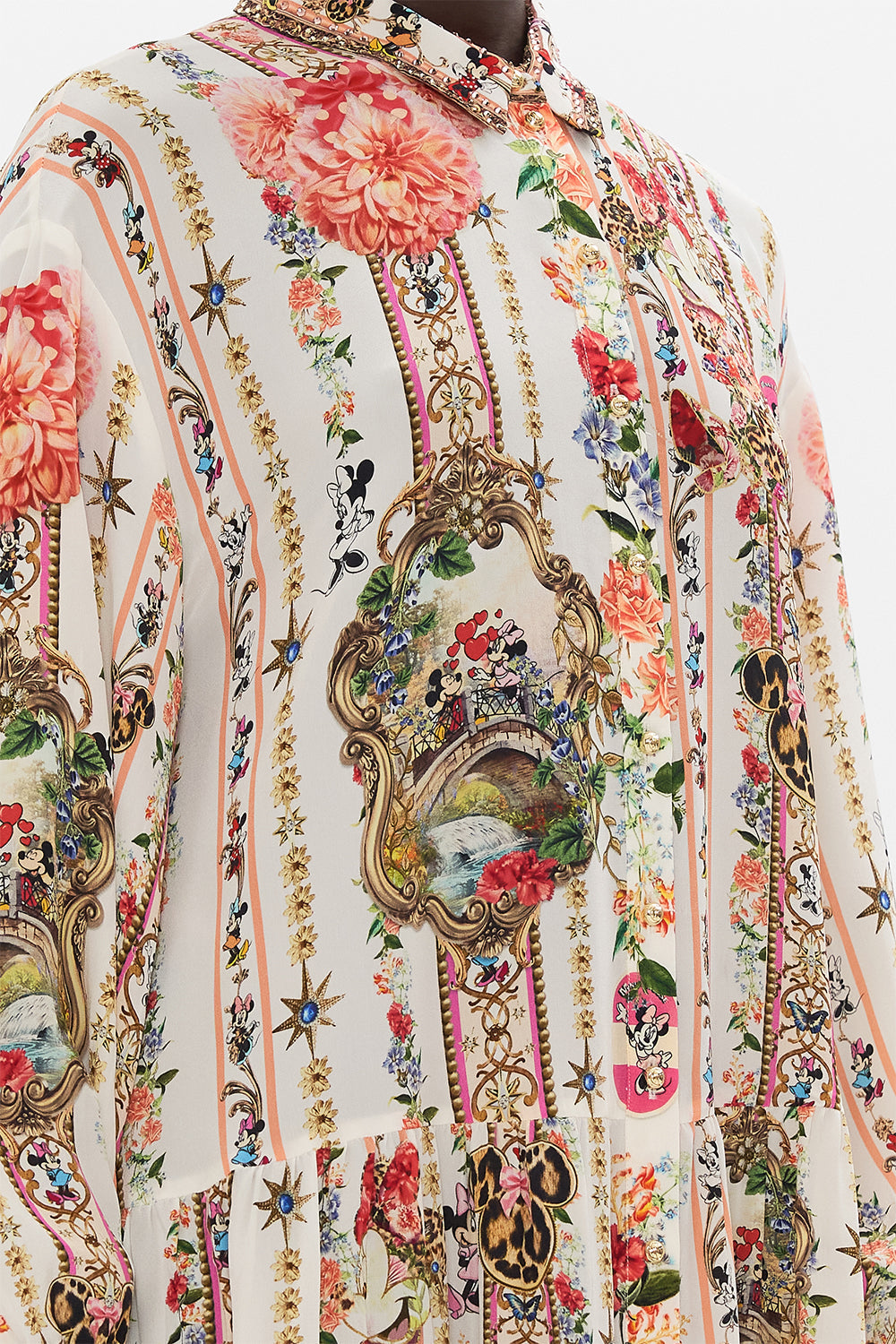 Detail view of model wearing Disney x CAMILLA silk shirt dress in Minnie Magic Forever print