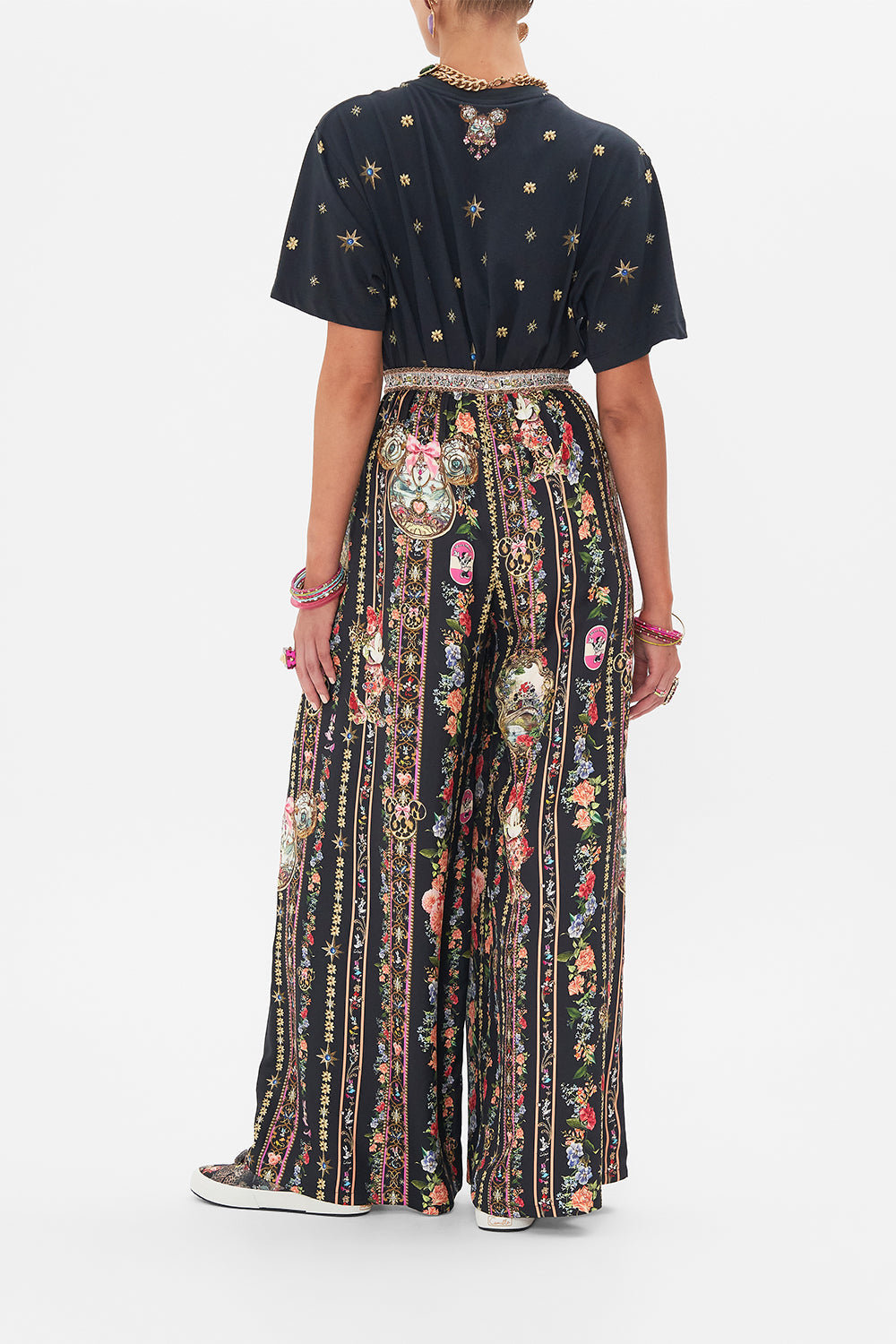 Back view of model wearing Disney x CAMILLA silk pants in Midnight At Minnies print