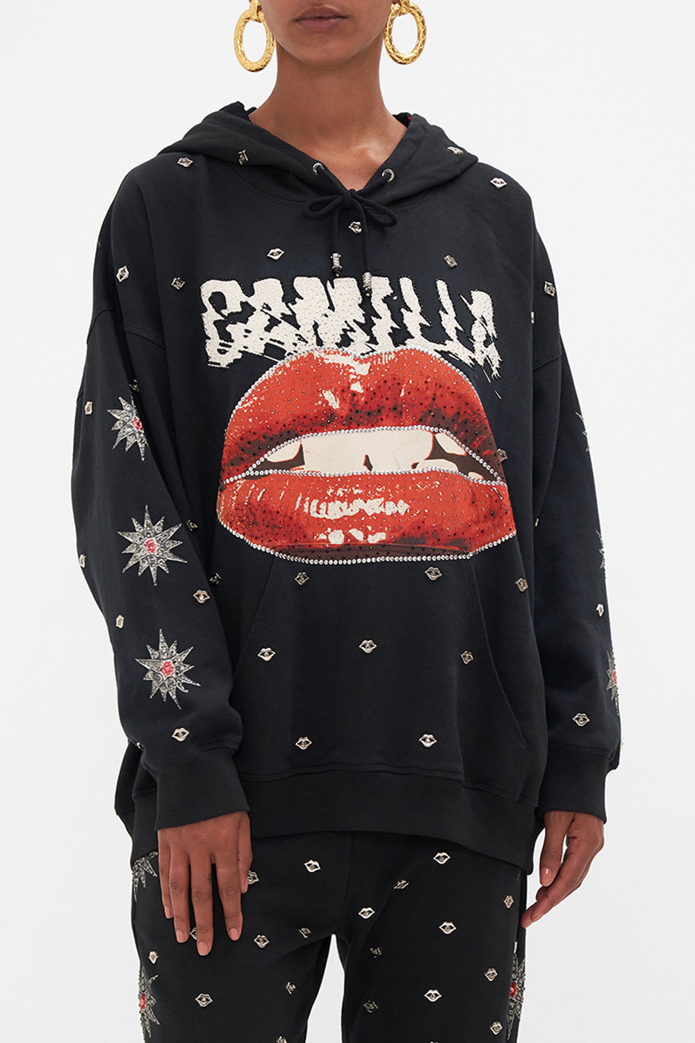 Crop view of model wearing CAMILLA black oversized hoodie in Chaos Magic print 