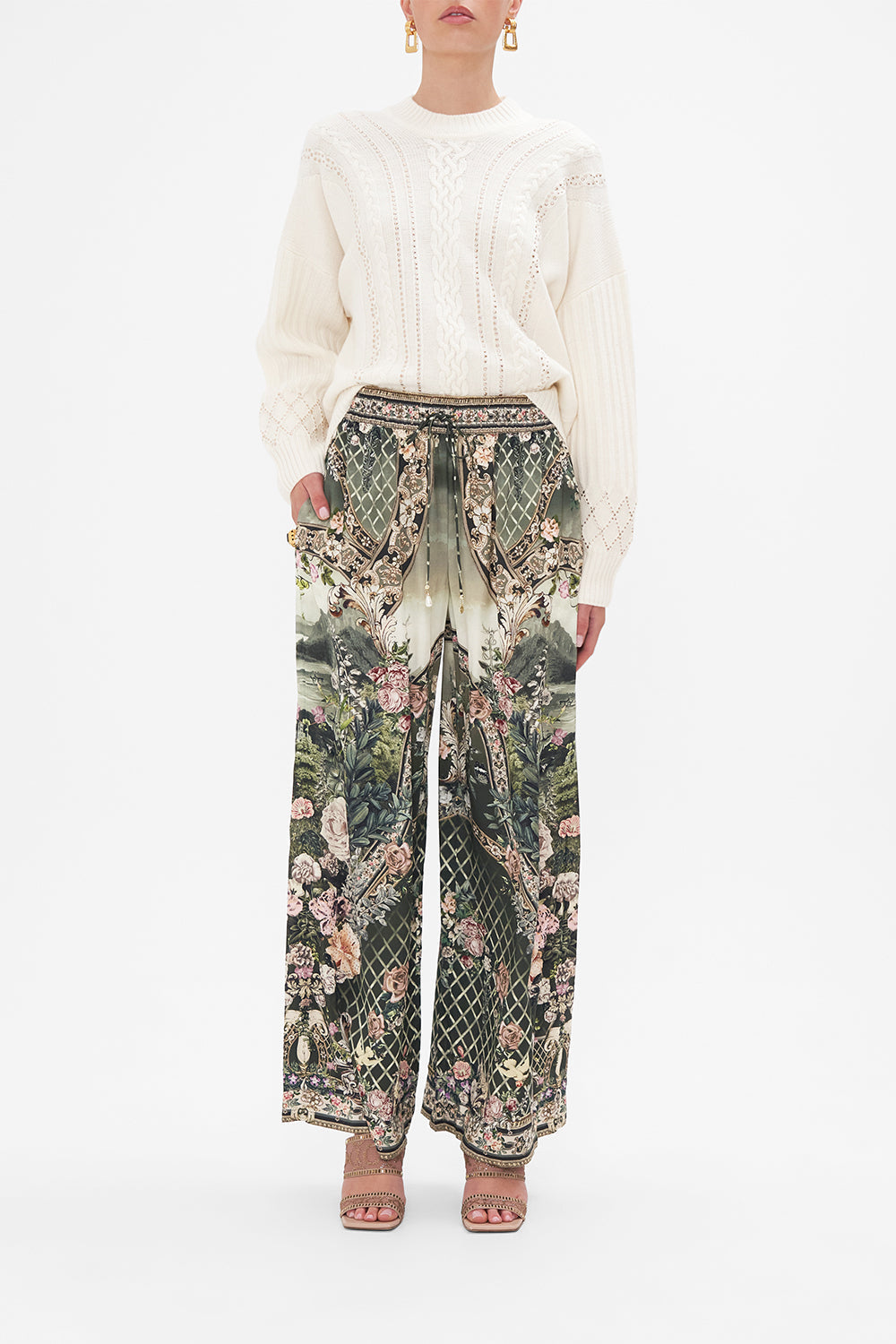 Front view of model wearing CAMILLA green floral silk pants in Garden Of Good Fortune print