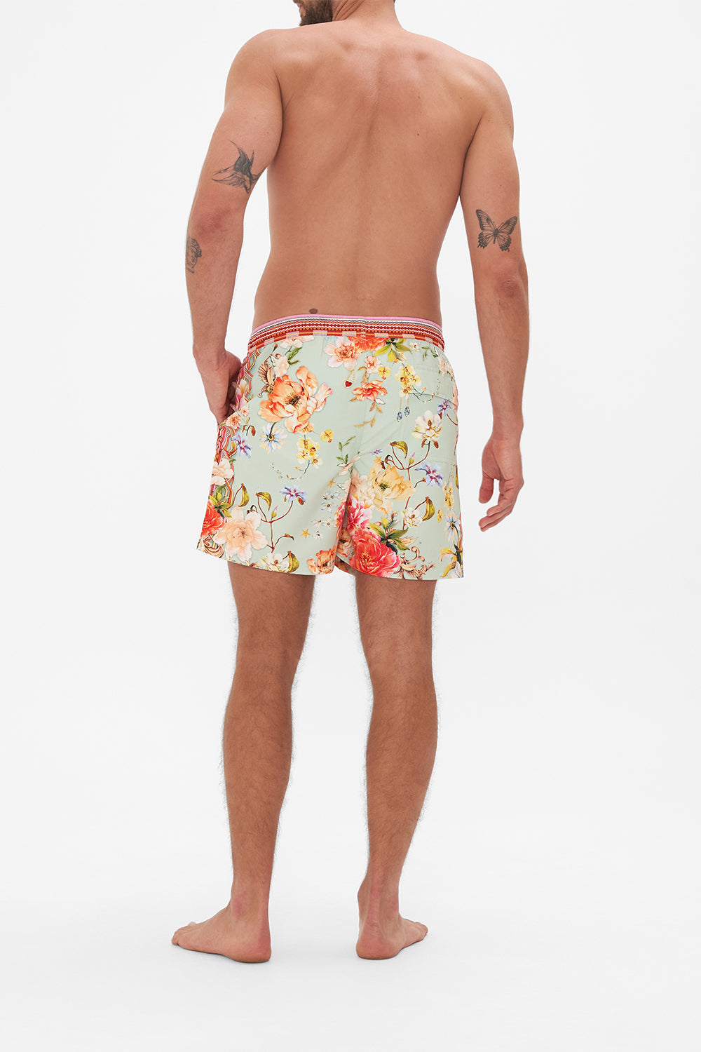 Back view of model wearing Hotel Franks by CAMILLA mens floral print boardshorts in Talk The Walk print