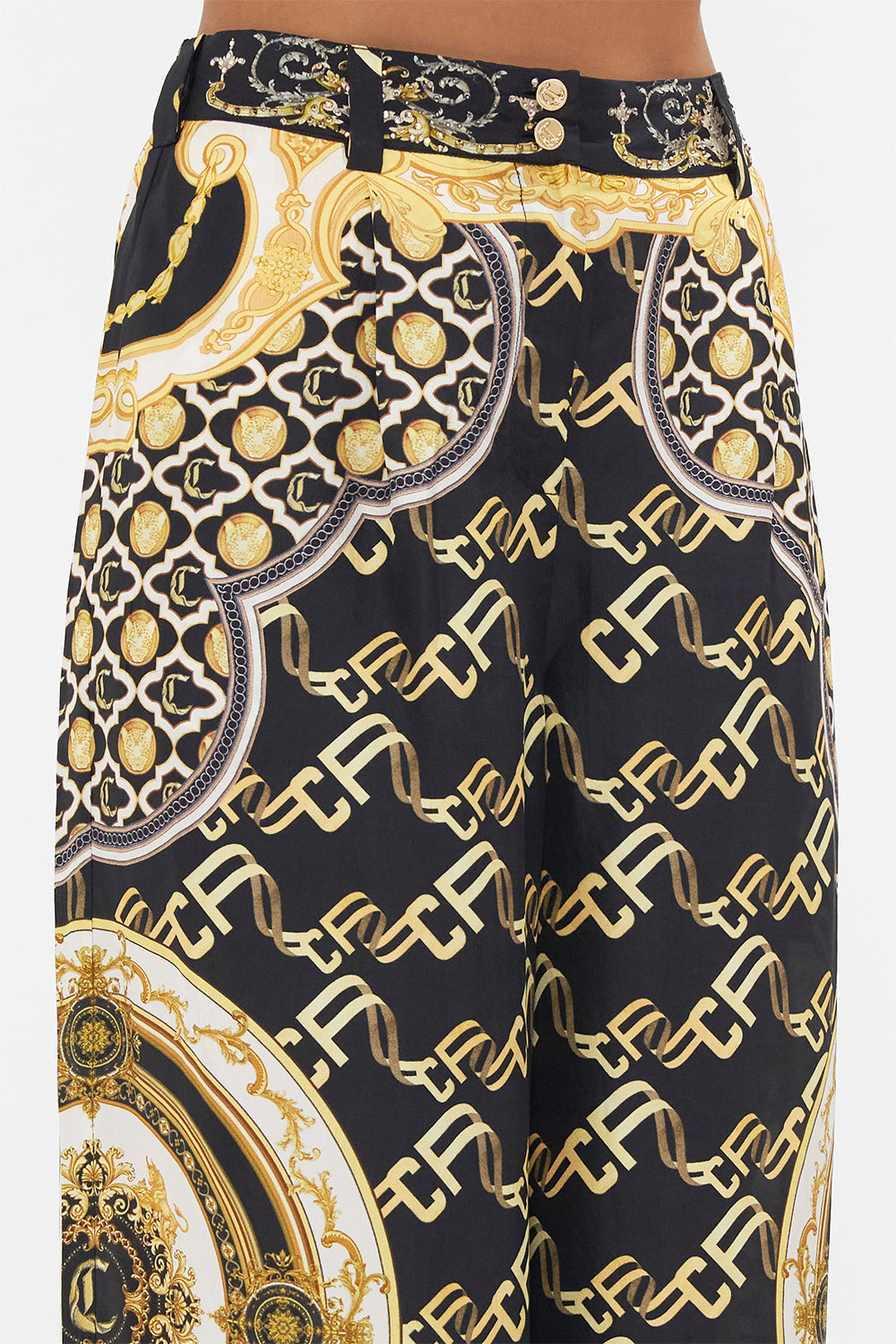 Detail view of model wearing CAMILLA black silk pants in Tether Me Not print