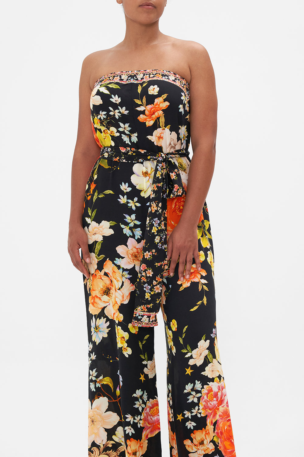 Crop view of model wearing CAMILLA strapless floral silk jumpsuit in Secret History print