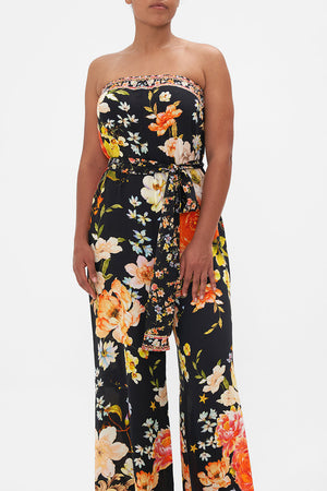 Crop view of model wearing CAMILLA strapless floral silk jumpsuit in Secret History print