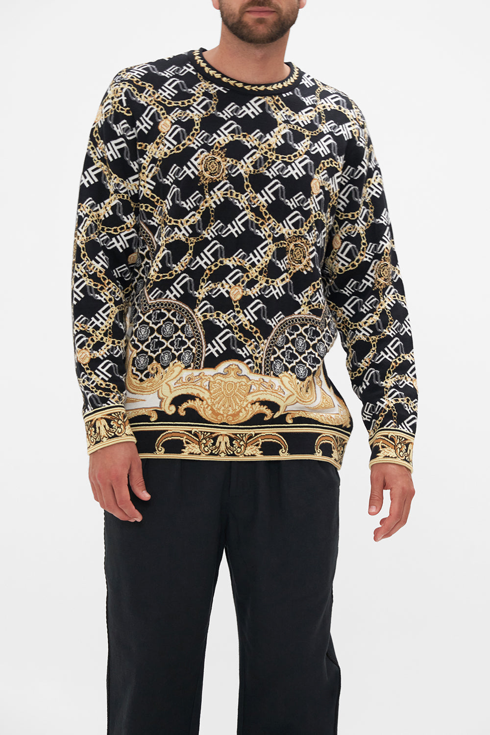 Crop view of model wearing Hotel Franks by CAMILLA mens oversized  knit sweater in black and gold Tether Me Not print