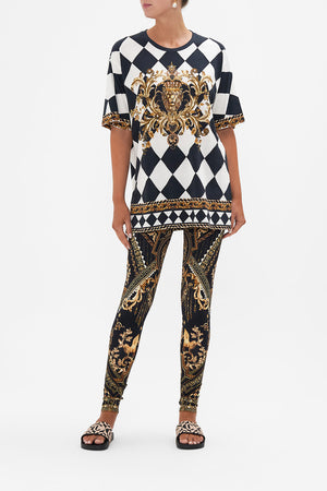 Front view of model wearing CAMILLA black and gold leggings in Duomo Dynasty print
