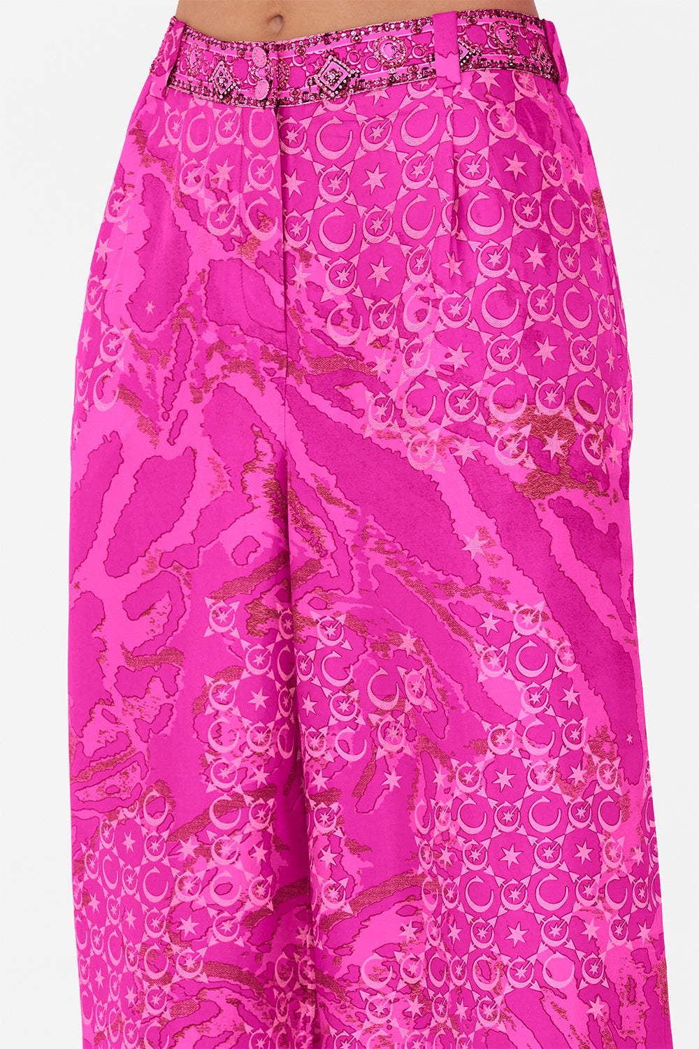 Detail view of model wearing CAMILLA silk pants  in neon Song Of Sacrifice print