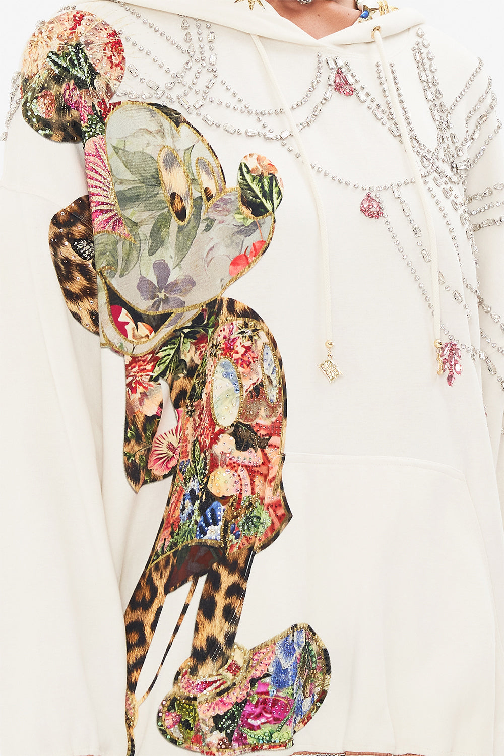 Detail view of model wearing Disney x CAMILLA hoodie in Minnie Magic Forever print