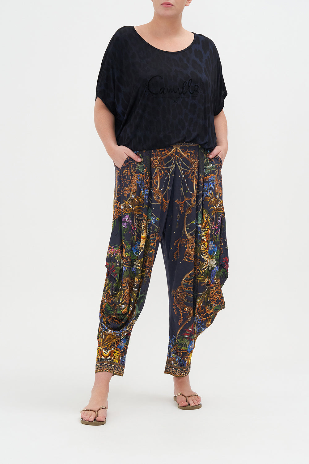 Front view of curvy model wearing CAMILLA plus size jersey drape pants in Tiger Tales print